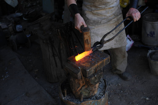 Almaty, Kazakhstan - 09.24.2015 : A blacksmith makes a metal holder for knives and tools in the workshop. - Photo, Image