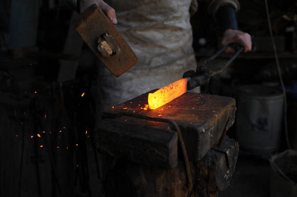 Almaty, Kazakhstan - 09.24.2015 : A blacksmith makes a metal holder for knives and tools in the workshop. - Zdjęcie, obraz
