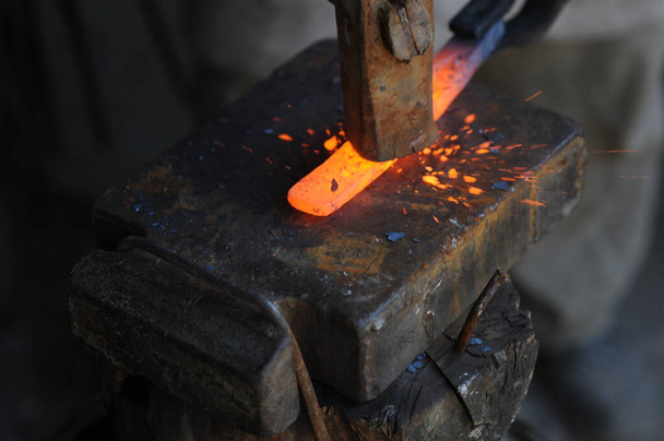Almaty, Kazakhstan - 09.24.2015 : A blacksmith makes a metal holder for knives and tools in the workshop. - Foto, imagen
