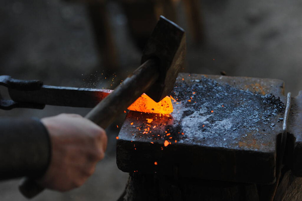 Almaty, Kazakhstan - 09.24.2015 : A blacksmith makes a metal holder for knives and tools in the workshop. - Fotó, kép