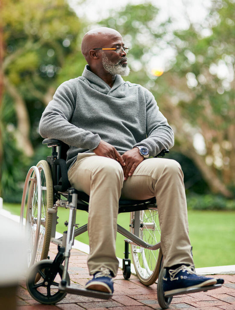 Подышать свежим воздухом. Полный снимок красивого пожилого мужчины, сидящего в инвалидном кресле снаружи - Фото, изображение