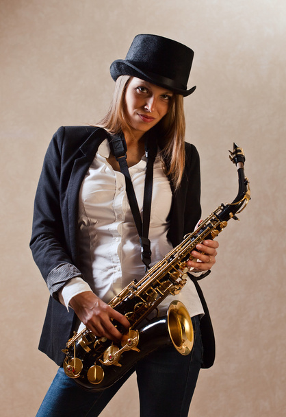 Young beautiful woman with saxophone - 写真・画像