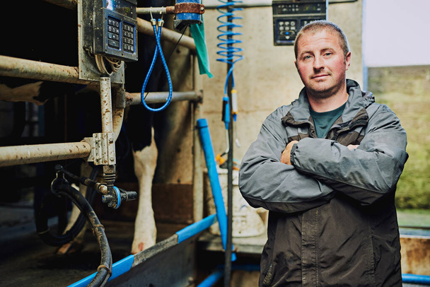 I care about my cattle. Cropped portrait of a male farmer standing with his arms folded in his dairy factory - Zdjęcie, obraz