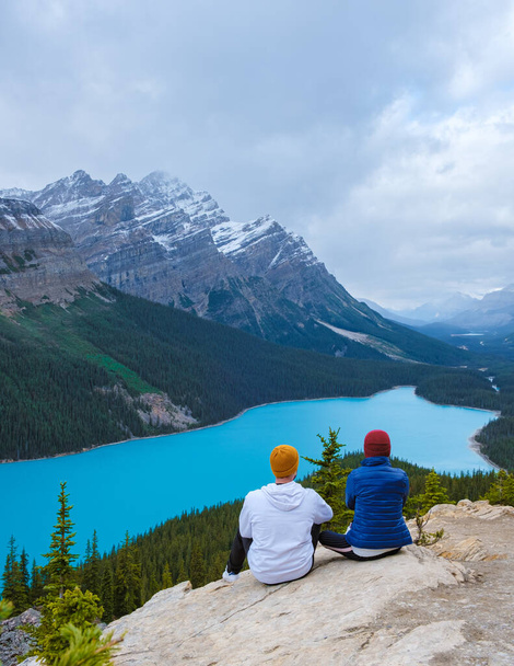 Lake Peyto in Banff National Park, Canada. Mountain Lake as a fox head is popular among tourists in Canada driving the icefields parkway. A couple of men and women looking out over the lake - Zdjęcie, obraz