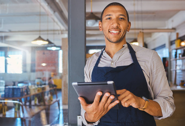 Restaurant entrepreneur with tablet, leaning on door and open to customers portrait. Owner, manager or employee of a startup fast food store, cafe or coffee shop business standing happy with a smile. - Fotó, kép