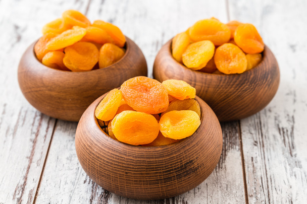 Сушені абрикоси в дерев'яній мисці
 - Фото, зображення