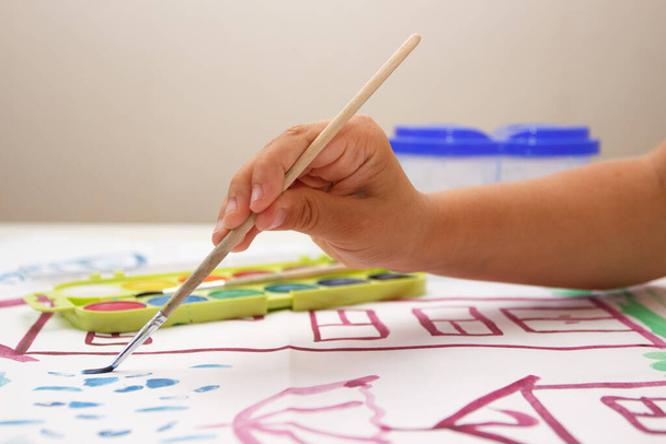 Child drawing a picture by watercolor, back to school concept - 写真・画像