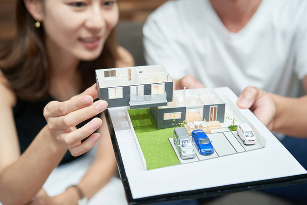 Man and woman looking at a model of a house in a room - Foto, Imagem