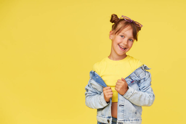 Portrait of surprised cute little toddler girl child over yellow background. Looking at camera.  Advertising childrens products. - Φωτογραφία, εικόνα