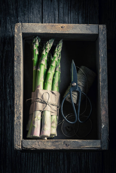 Fresh and spring green asparagus in rustic wooden box - Fotó, kép