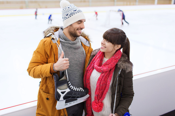 happy couple with ice-skates on skating rink - Foto, imagen