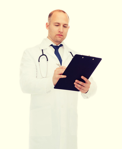 serious male doctor with clipboard and stethoscope - Fotó, kép