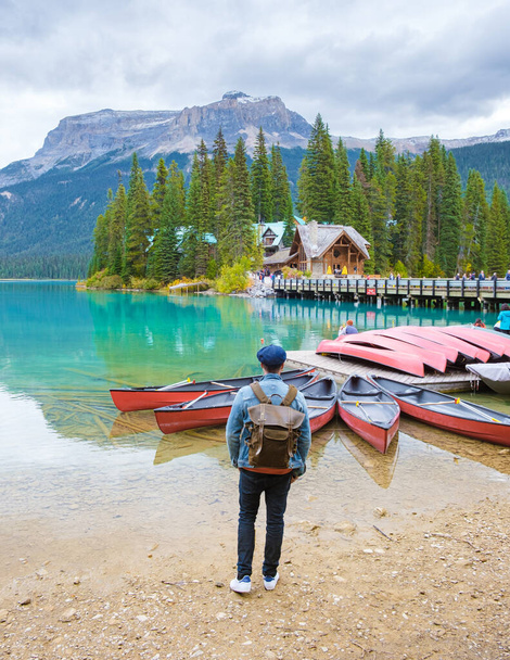 Изумрудное озеро Йохо Национальный парк Канада Британская Колумбия. красивое озеро в Канадских Скалистых горах в осенний осенний сезон. Молодые люди с сумкой стоят у озера - Фото, изображение