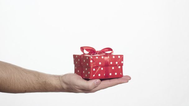Человек с красной коробкой подарков в ладони
 - Фото, изображение