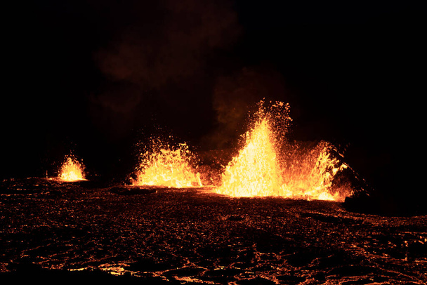 Volcano eruption at Meradalir near Fagradalsfjall, Iceland. Erupting magma and flowing lava at night. Unique natural attraction. - Photo, image