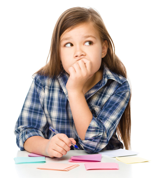 Κορίτσι εγγράφως σχετικά με αυτοκόλλητα χρώμα, με στυλό - Φωτογραφία, εικόνα