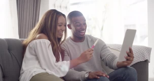 Excited pregnant couple video call on digital tablet phone share good news about expecting baby on living room home sofa. Happy black woman and man hold positive pregnancy test start family together - Materiaali, video