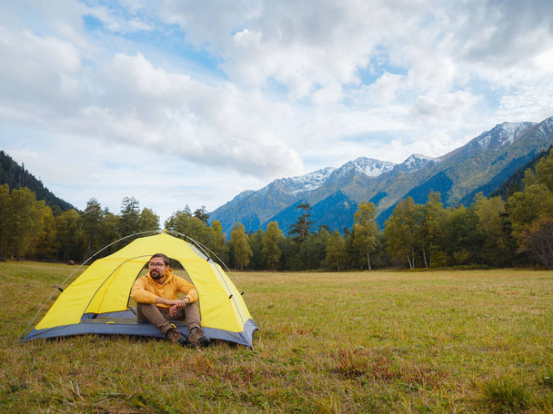 trip to Caucasus mountains, Arkhyz, Teberdinsky reserve. Man traveler relaxing in mountains in tent camping outdoor Travel adventure lifestyle concept hiking active vacations. - Photo, image