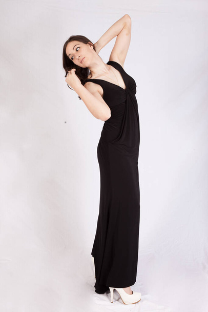 Pretty woman in a black dress looking thoughtful - Fotó, kép