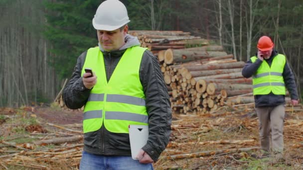 Lesní úředníci mluví na mobilní telefony v lese - Záběry, video