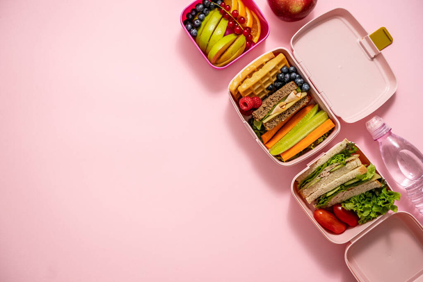 Healthy lunch to go. Sandwitches, Fruits and vegetables packed in lunch box. Healthy eating concept. View from above with flat lay. - Фото, изображение