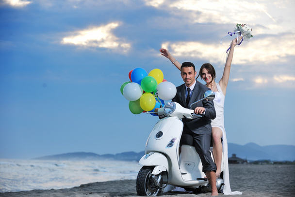 Just married couple on the beach ride white scooter - Valokuva, kuva