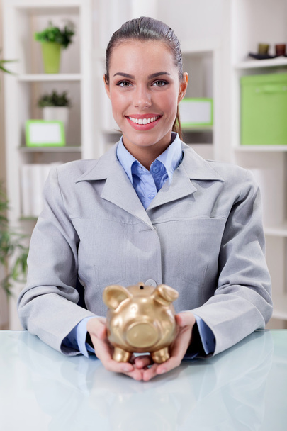 muotokuva onnellinen hymyilevä liiketoiminnan nainen, jolla kulta possu kielto
 - Valokuva, kuva