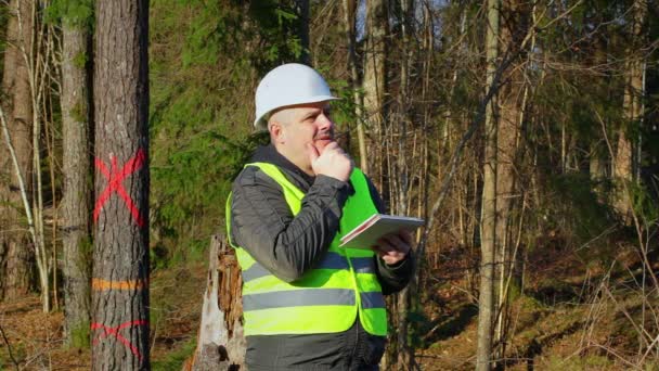 Nachdenklicher Forsttechniker mit Tablet-PC in Baumnähe - Filmmaterial, Video