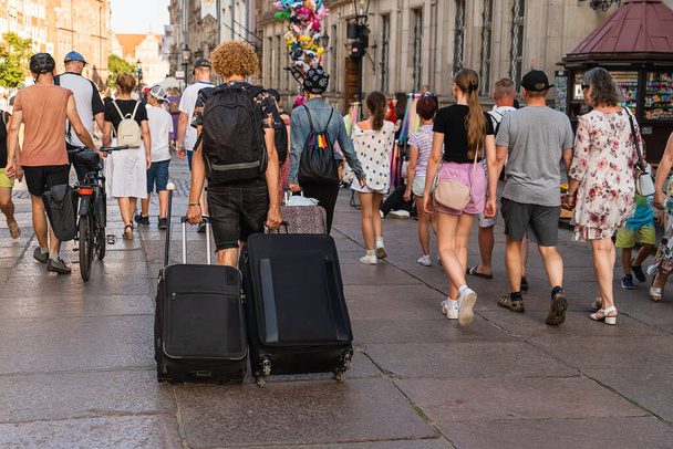 Много туристов на главной улице в историческом центре Гданьска пешком в солнечный летний день, туристические достопримечательности Польши, европейский туризм - Фото, изображение