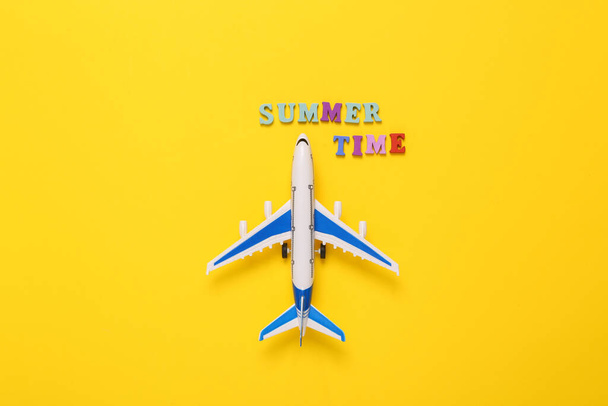 Concept de voyage. Modèle d'avion de passagers avec texte heure d'été sur fond jaune. Vue de dessus. Pose plate - Photo, image