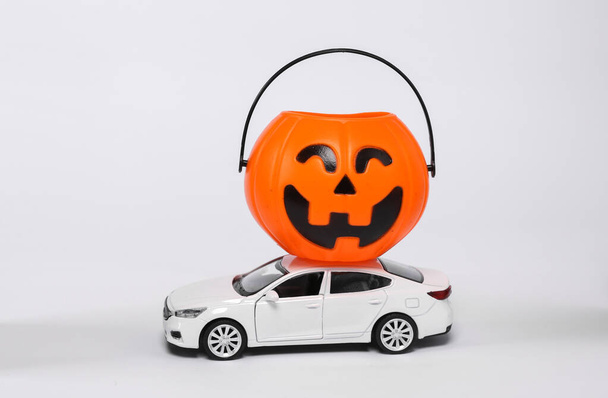 Little car model with halloween jack pumpkin bucket isolated on white background. Trick or Treat - Valokuva, kuva