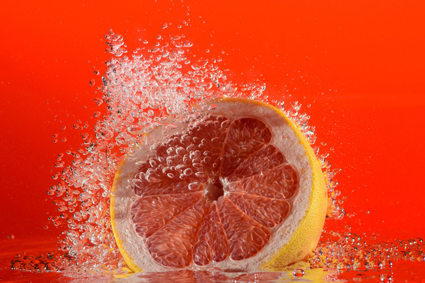 Grapefruit im Wasser mit Blasen.  - Foto, Bild