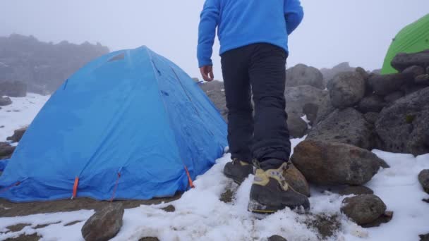мужчина сидит в палатке, используя смартфон  - Кадры, видео
