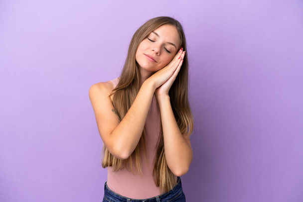Young Lithuanian woman isolated on purple background making sleep gesture in dorable expression - Photo, Image