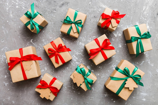 Цветные ремесленные подарочные коробки с красочными лентами на цветном фоне. Коллекция рождественских подарков . - Фото, изображение