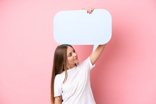 Young Lithuanian woman isolated on pink background holding an empty speech bubble - Fotó, kép