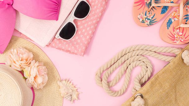 Summer beach arrangement on pastel pink background. Beach accessories concept flat lay - Фото, изображение