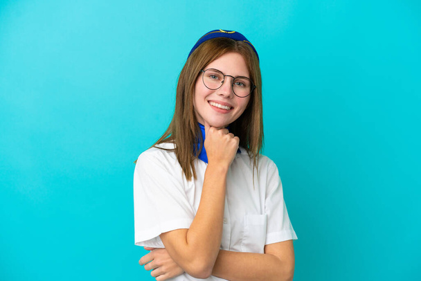 Aereo hostess donna inglese isolato su sfondo blu con occhiali e sorridente - Foto, immagini