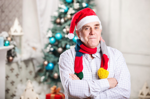 Senior Mann mit Weihnachtsmütze auf Weihnachtshintergrund - Foto, Bild