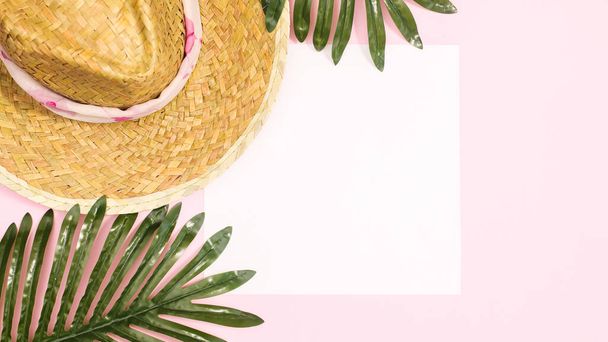 Summer beach background with straw hat palm leaves pastel pink background with copy space. Flat lay - Photo, image