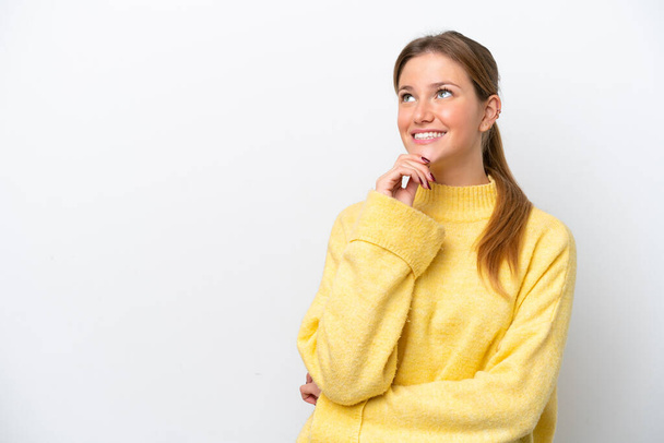 Mladá běloška žena izolované na bílém pozadí vzhlíží a usmívá se - Fotografie, Obrázek