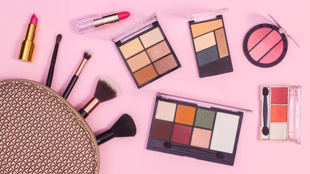 Make up products in cosmetics kit on pastel pink background. Flat lay - Zdjęcie, obraz