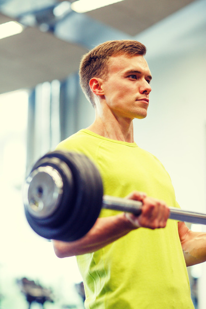 man doing exercise with barbell in gym - Photo, image