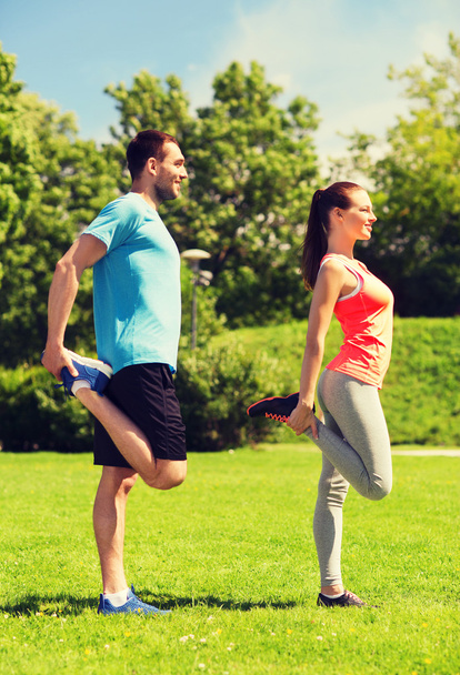 smiling couple stretching outdoors - Photo, image