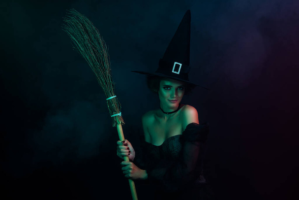 Photo of satanic tempting lady enjoy nightmare magic holding broom stick isolated on black dark colored background. - Foto, imagen