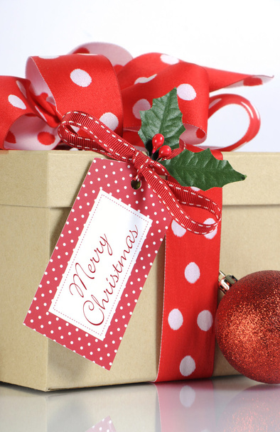 Festive holiday Kraft paper gift box with red polka dot ribbon - Photo, Image
