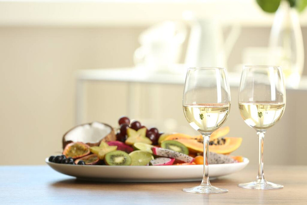 Herkullisia eksoottisia hedelmiä ja viiniä puinen pöytä - Valokuva, kuva
