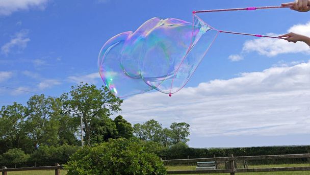 Burbuja de jabón gigante con una varita de burbuja - Foto, imagen