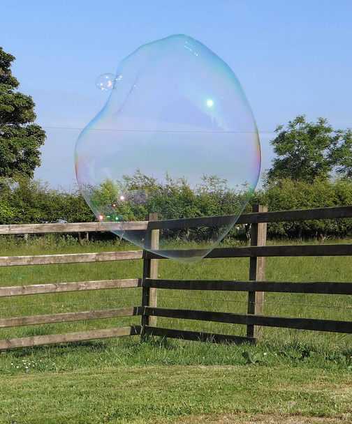 Riesige Seifenblase mit einem Blasenstab - Foto, Bild