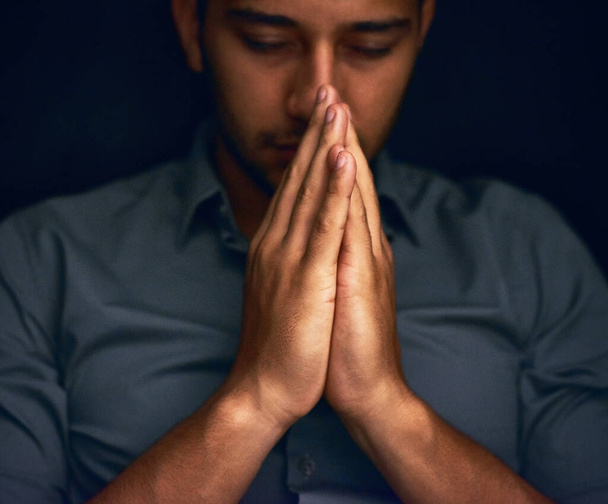 Give us this day our daily bread. Closeup shot of a young man praying with his eyes closed - Fotografie, Obrázek